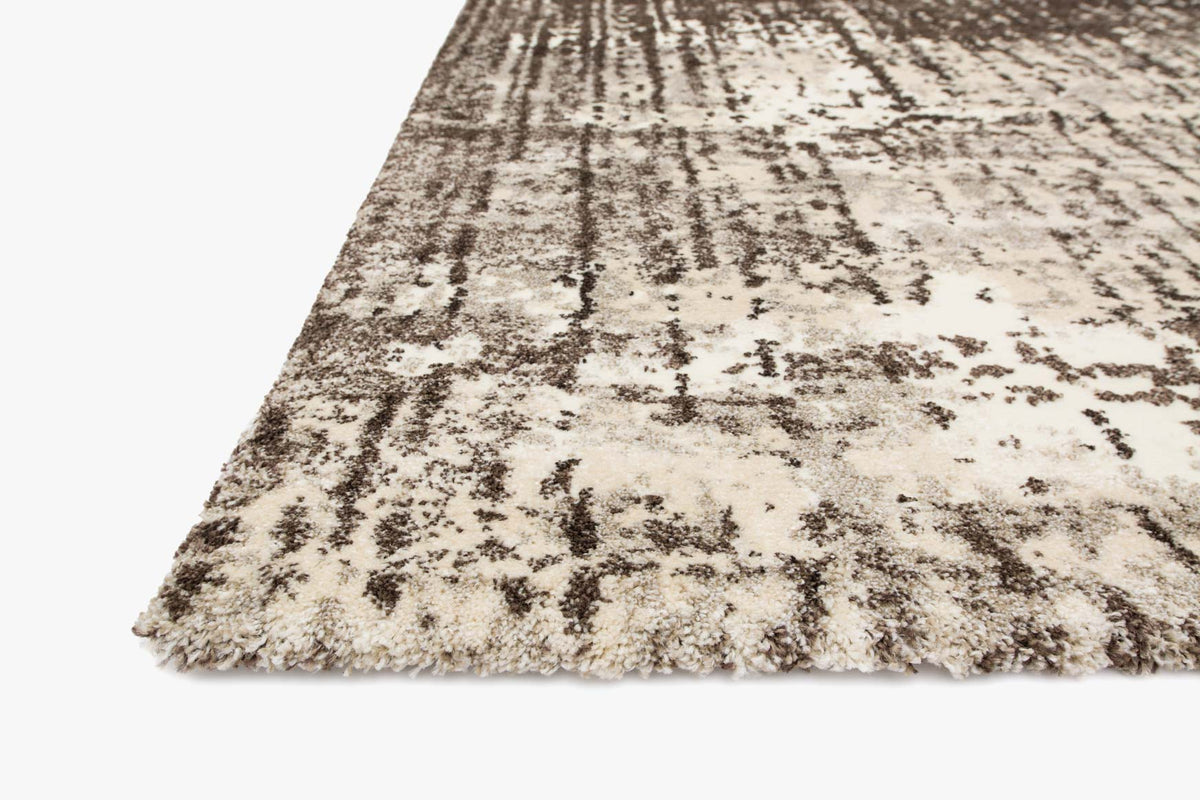 Ivory and brown abstract power-loomed rug corner view with distressed pile texture