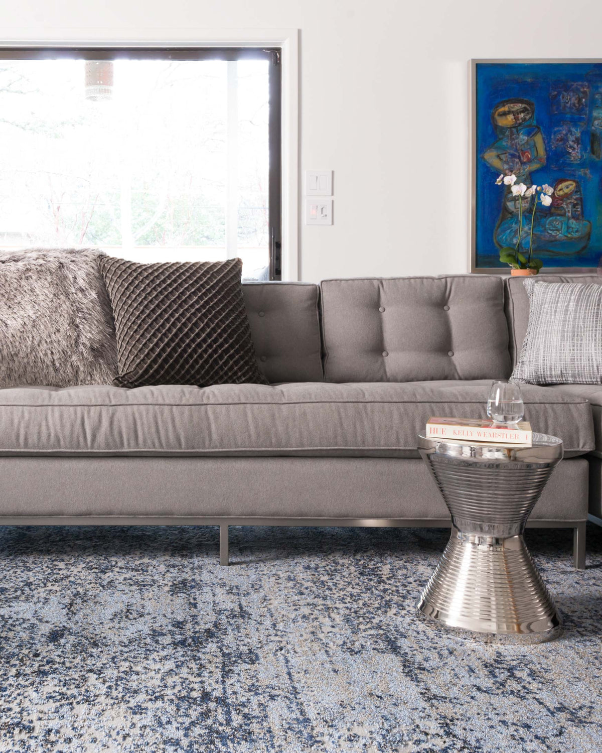 Blue and grey speckled area rug with low pile, shown on floor in living room.