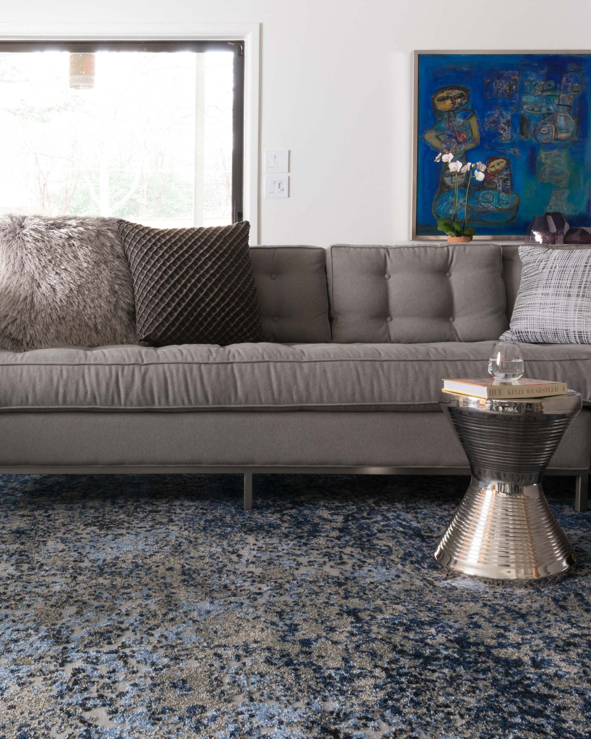Grey and navy speckled abstract area rug, rectangular shape, visible in living room.