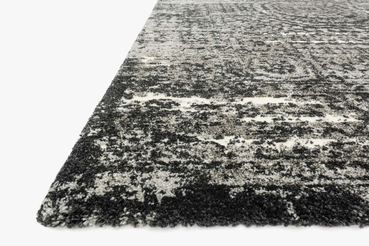 Corner view of distressed abstract rug with short pile, graphite and black