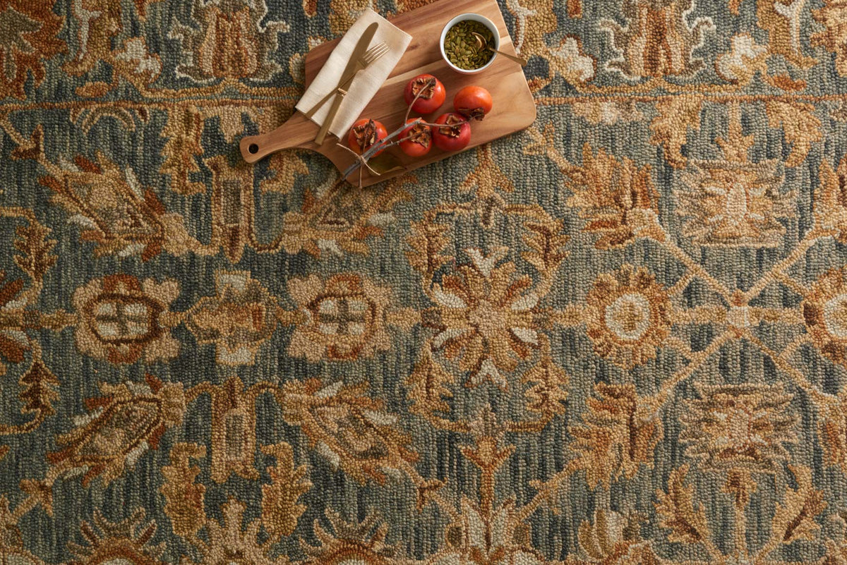 Hooked rug close-up showing textured pile and teal-blue with brown floral medallions