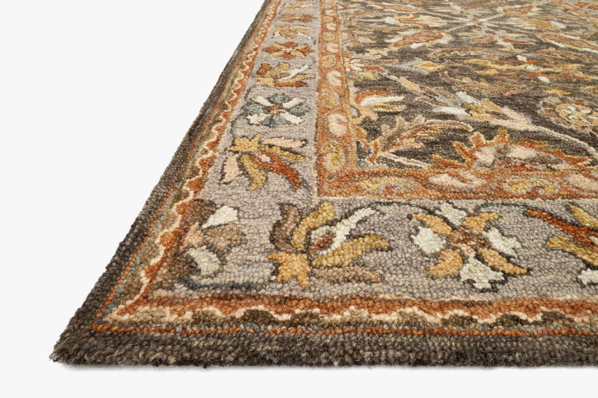 Hooked rug corner detail with taupe and gray ornate motifs and textured pile