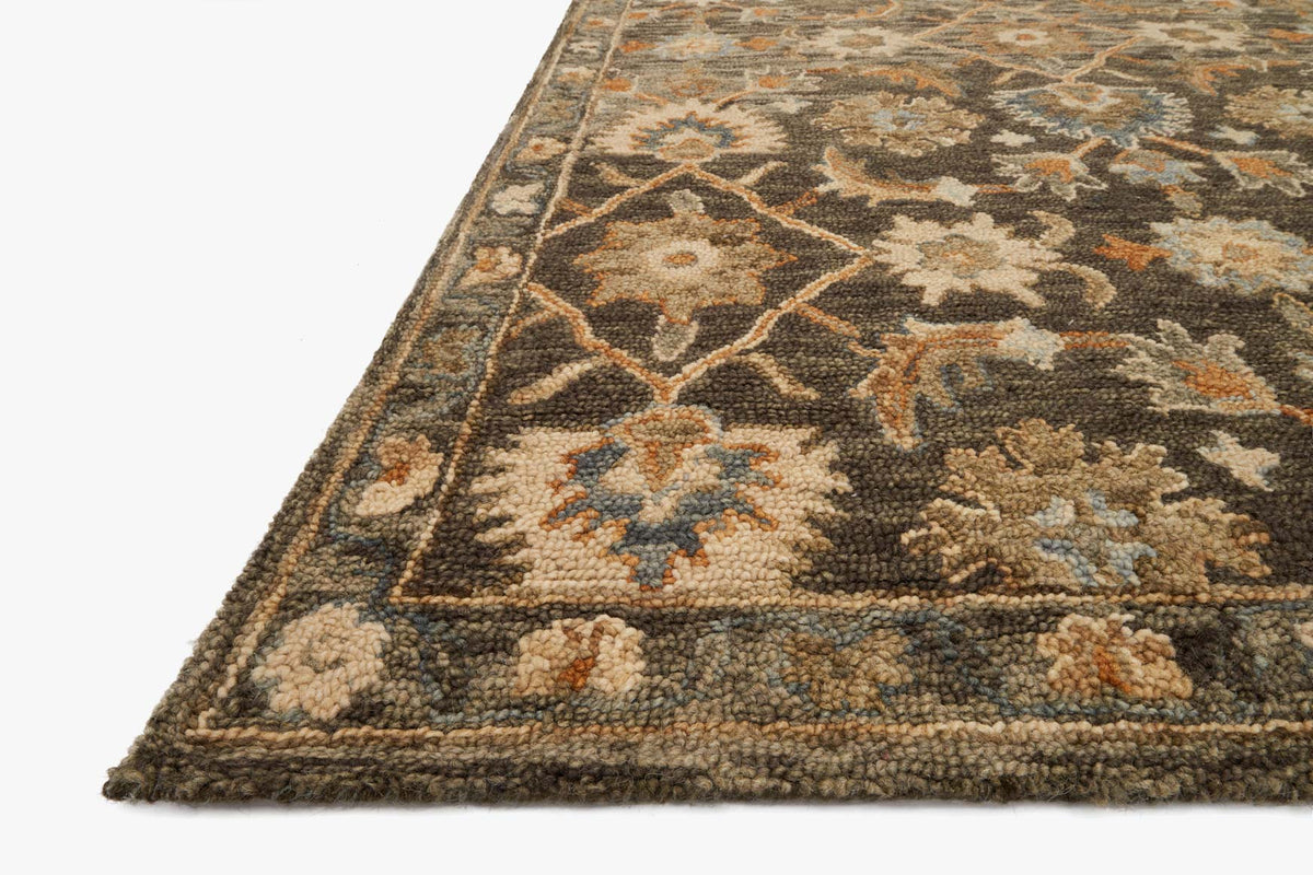 Corner close-up of traditional hooked rug, textured pile with taupe, gold and ivory motifs