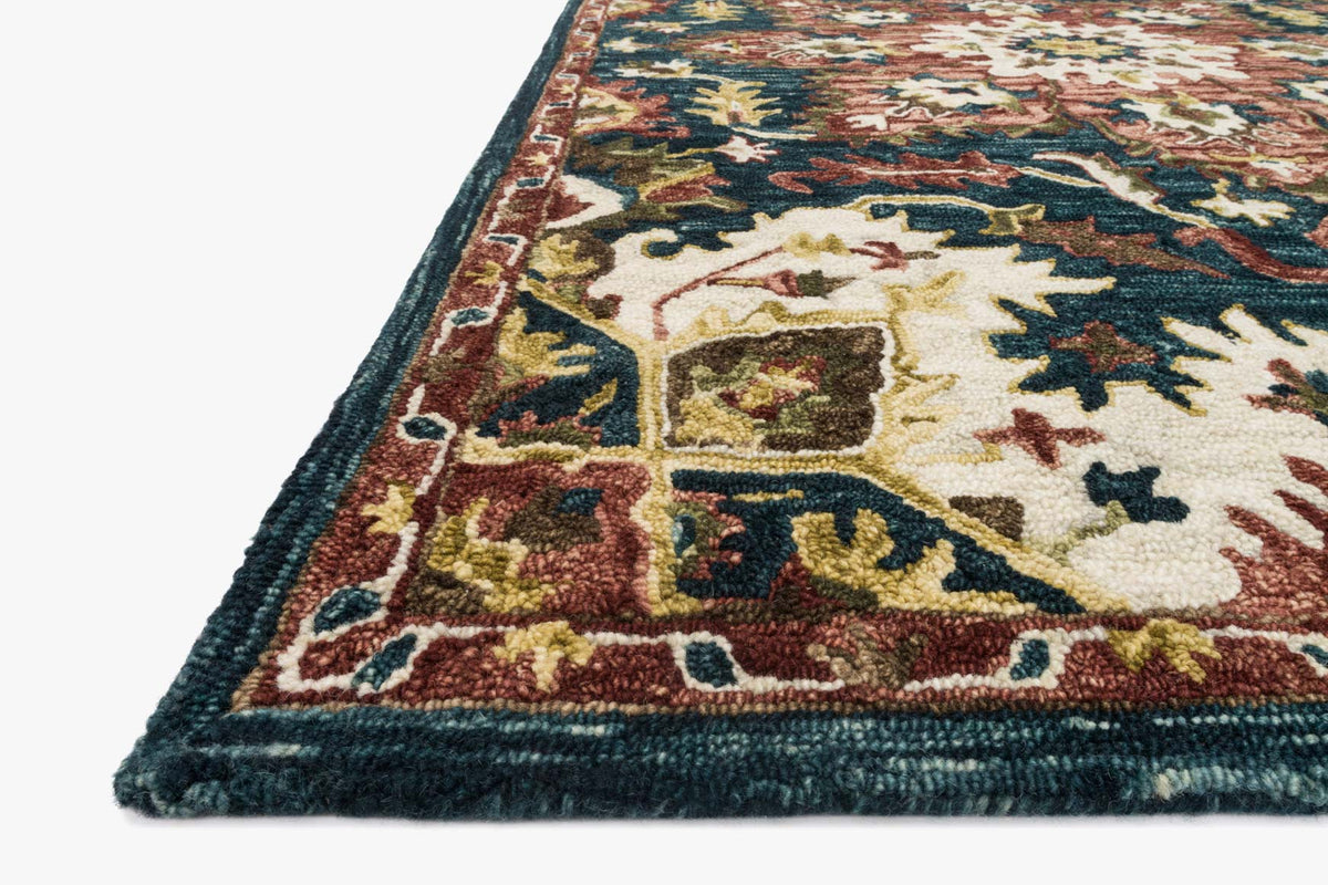 Hooked rug corner detail with teal edge, cream and multicolor floral geometric pattern