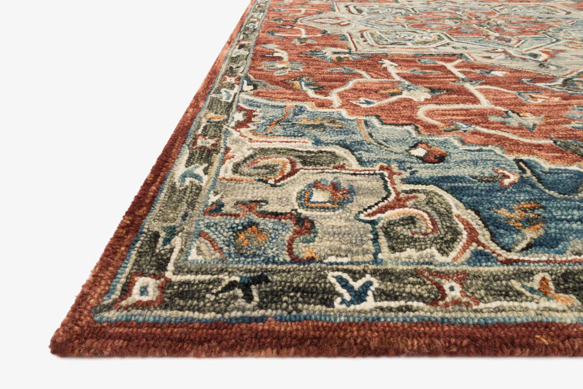 Traditional hooked rug corner close-up, red border with multicolor geometric pattern