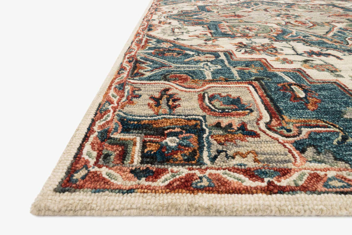 Hooked rug corner close-up with blue, red, and beige ornamental geometric design