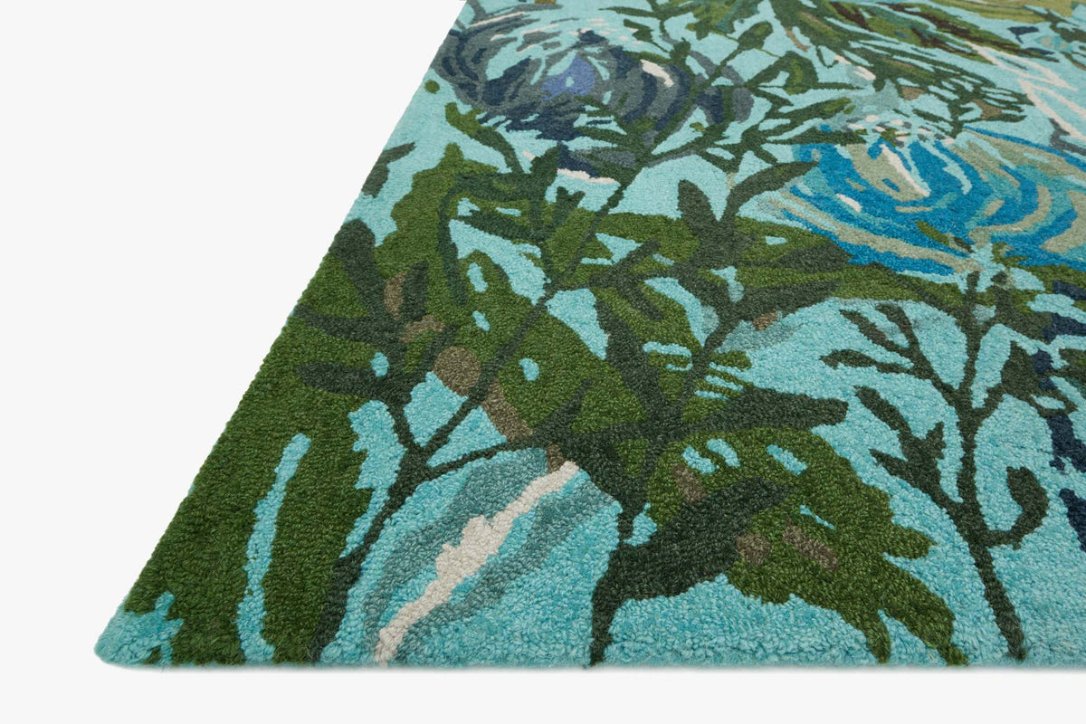 Hooked rug corner with aqua and green botanical pattern and textured short pile