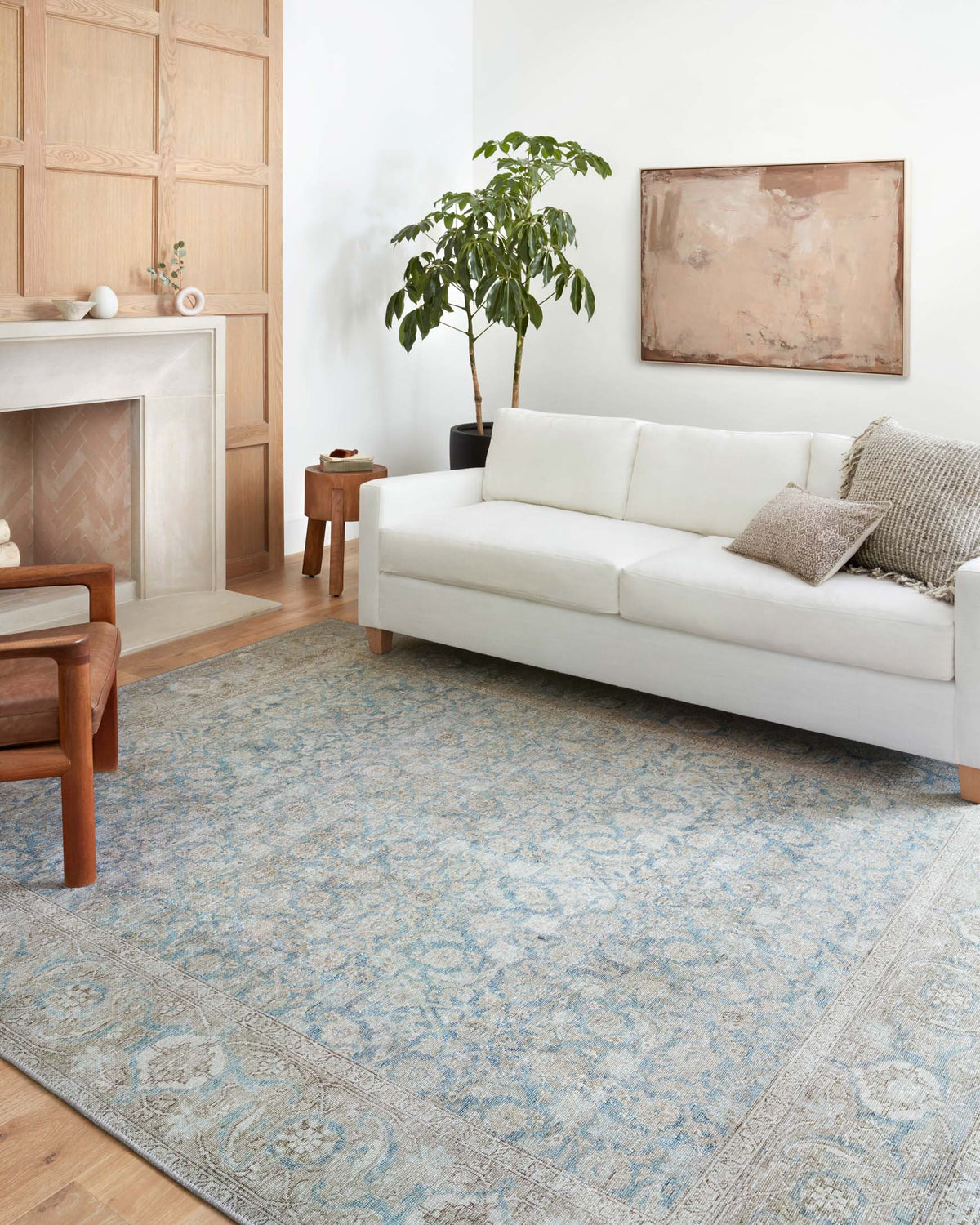 Light blue traditional rug with silver-toned pattern in a room setting
