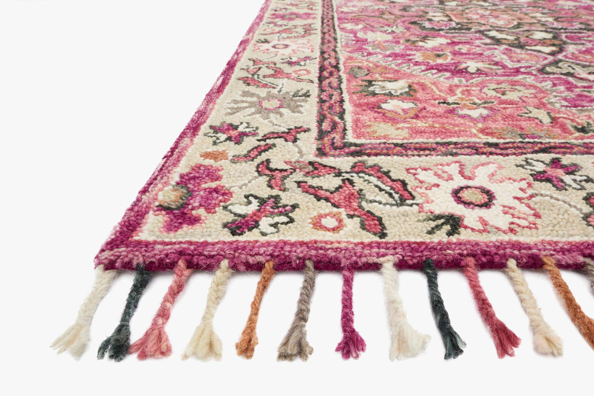 Transitional hooked rug corner detail, raspberry and taupe pattern with multicolor fringe.