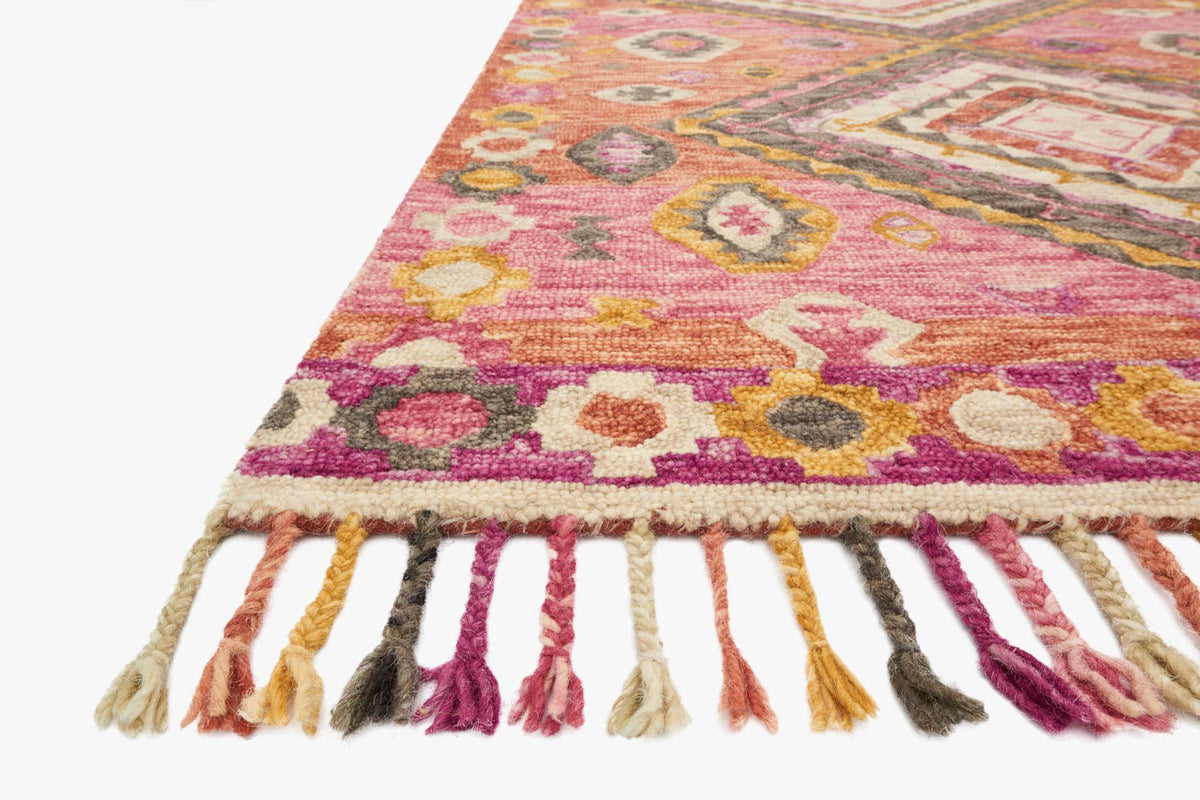 Hooked rug corner with multicolor floral/diamond motifs in pink, yellow, purple; long fringe