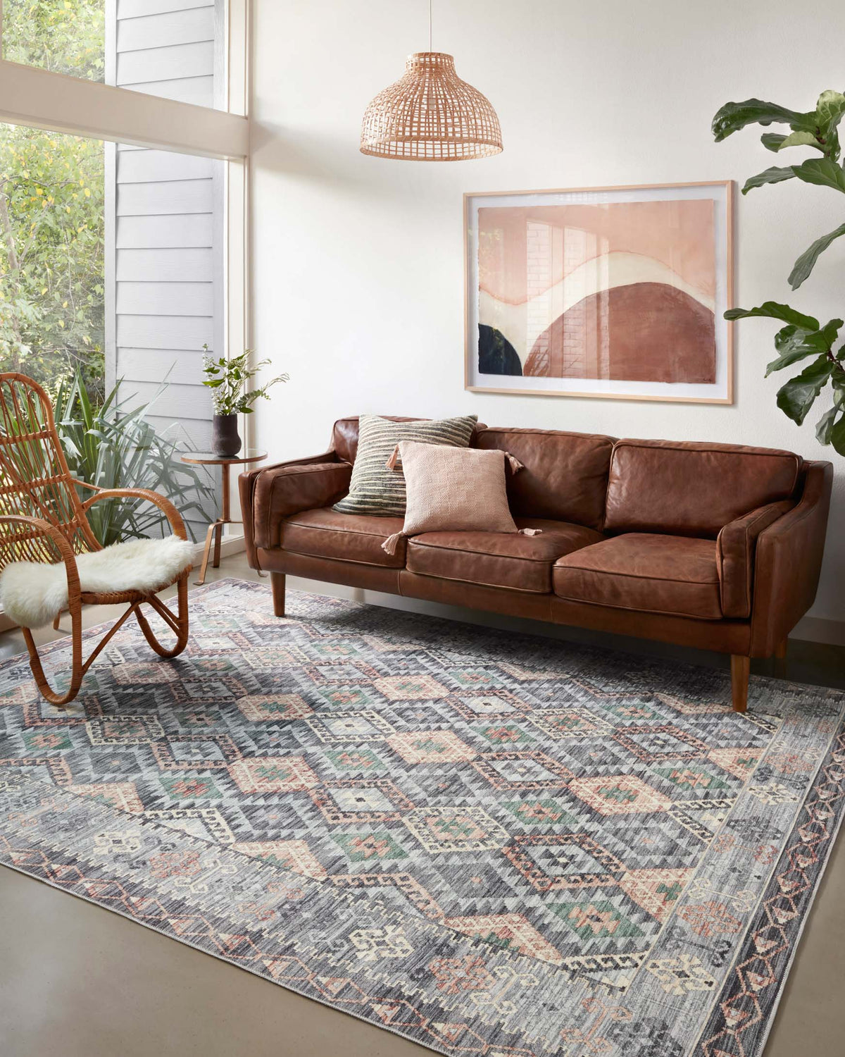Grey geometric area rug with multicolor diamond pattern, shown in a living room