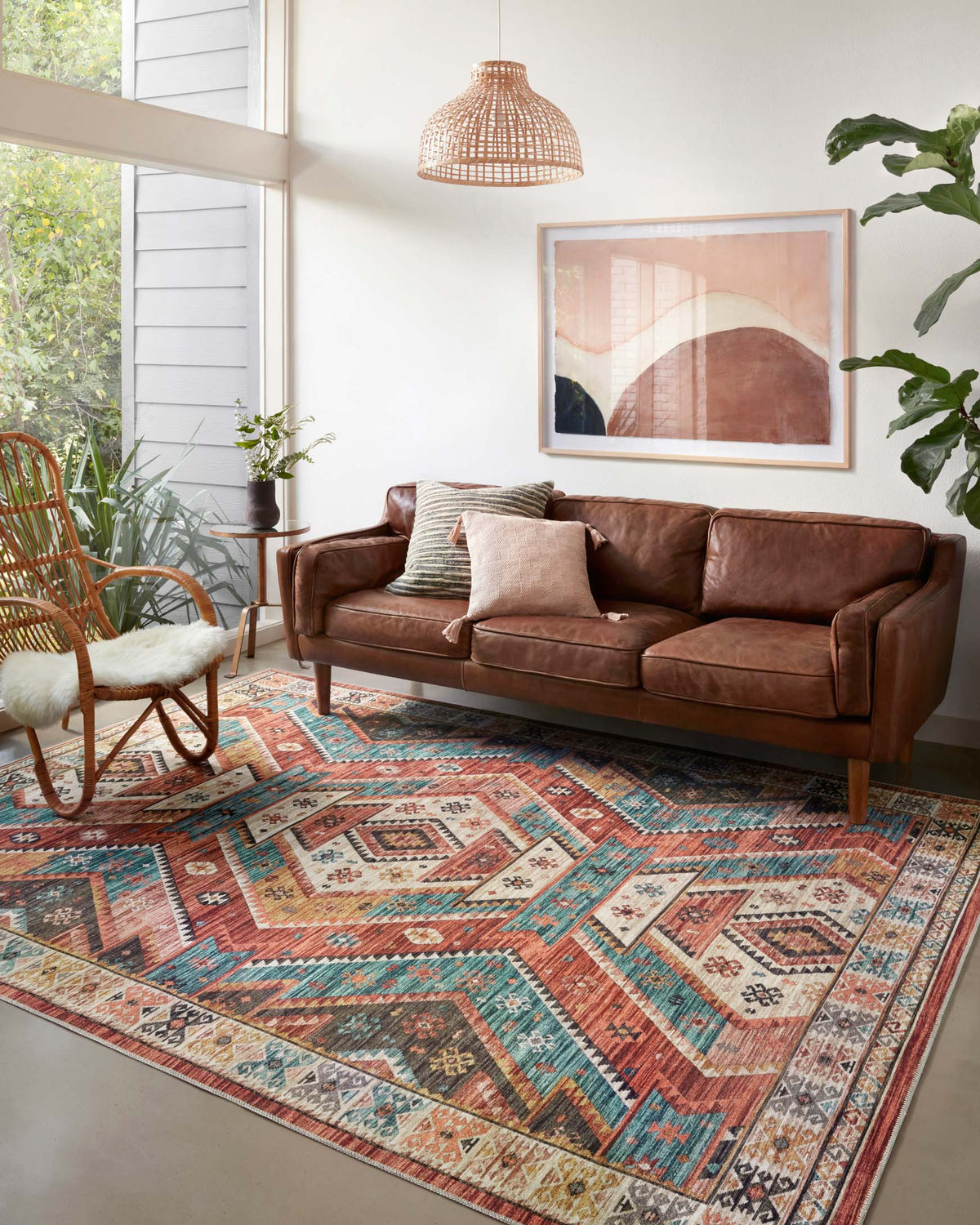 Geometric red and teal traditional rug laid on dark wood floor in a living room