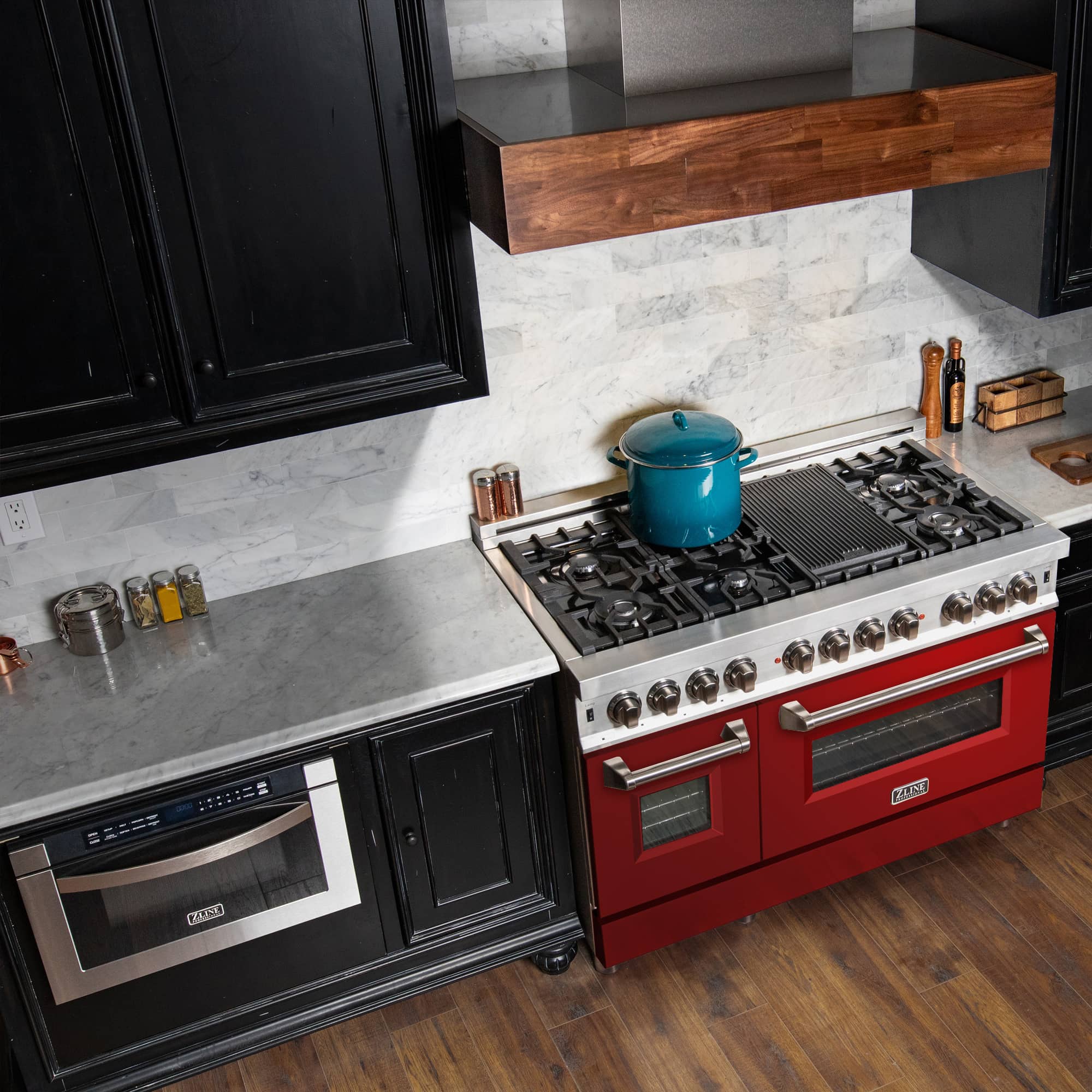 Red dual fuel range in kitchen with black burner grates and stainless knobs
