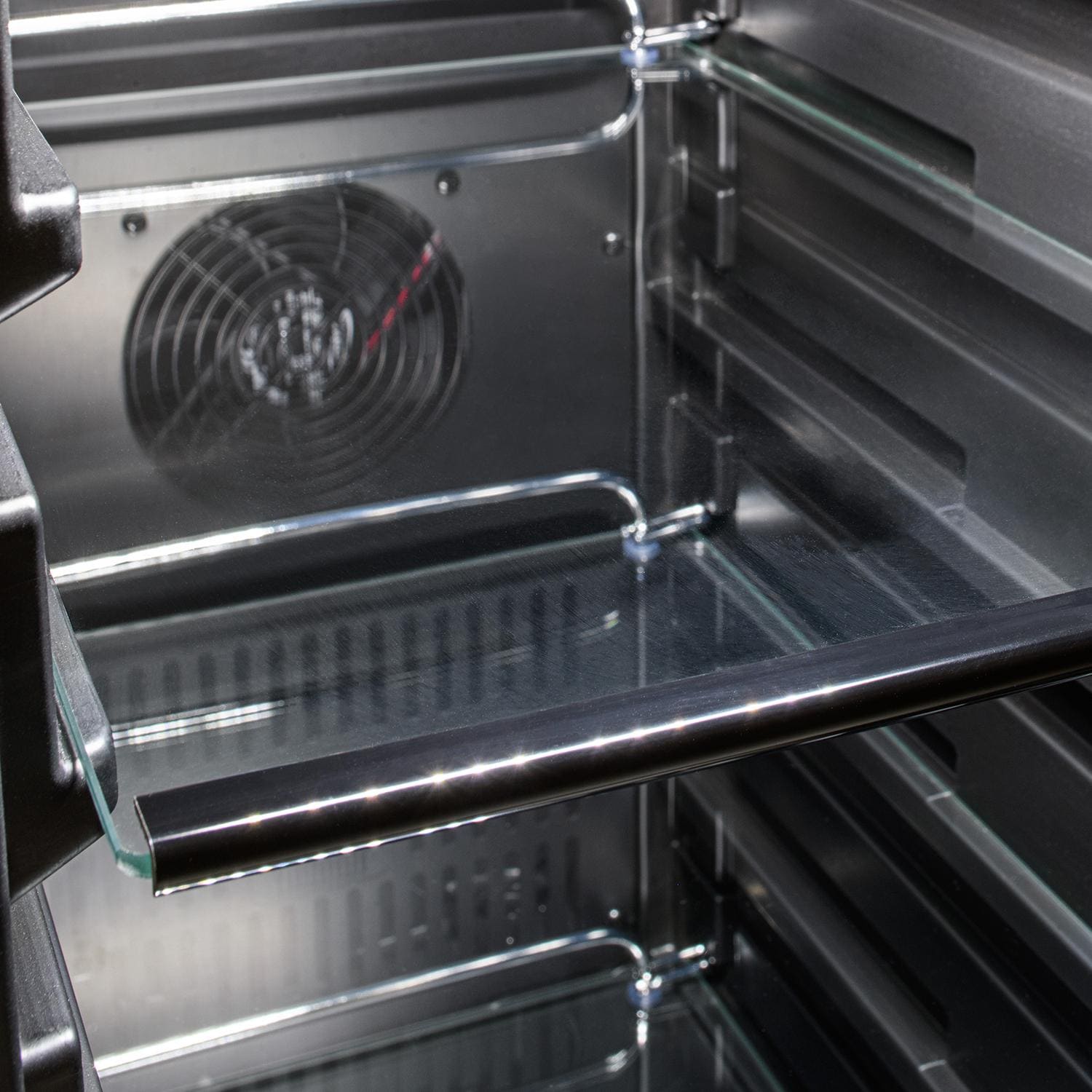 Compact refrigerator interior with glass shelves, chrome trim, and air fan grille at back