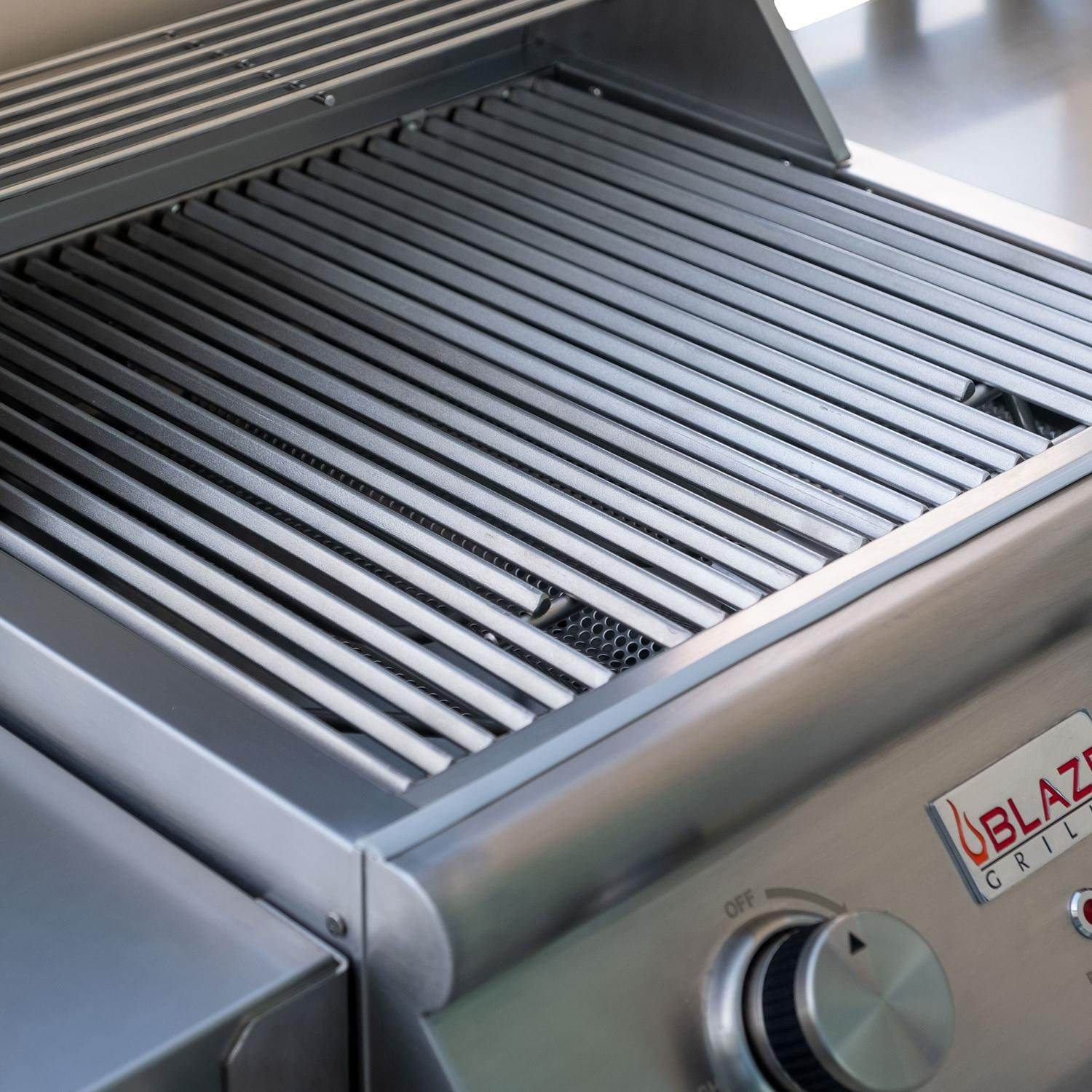 Electric grill cooking grate with parallel bars and heat slots on stainless hood