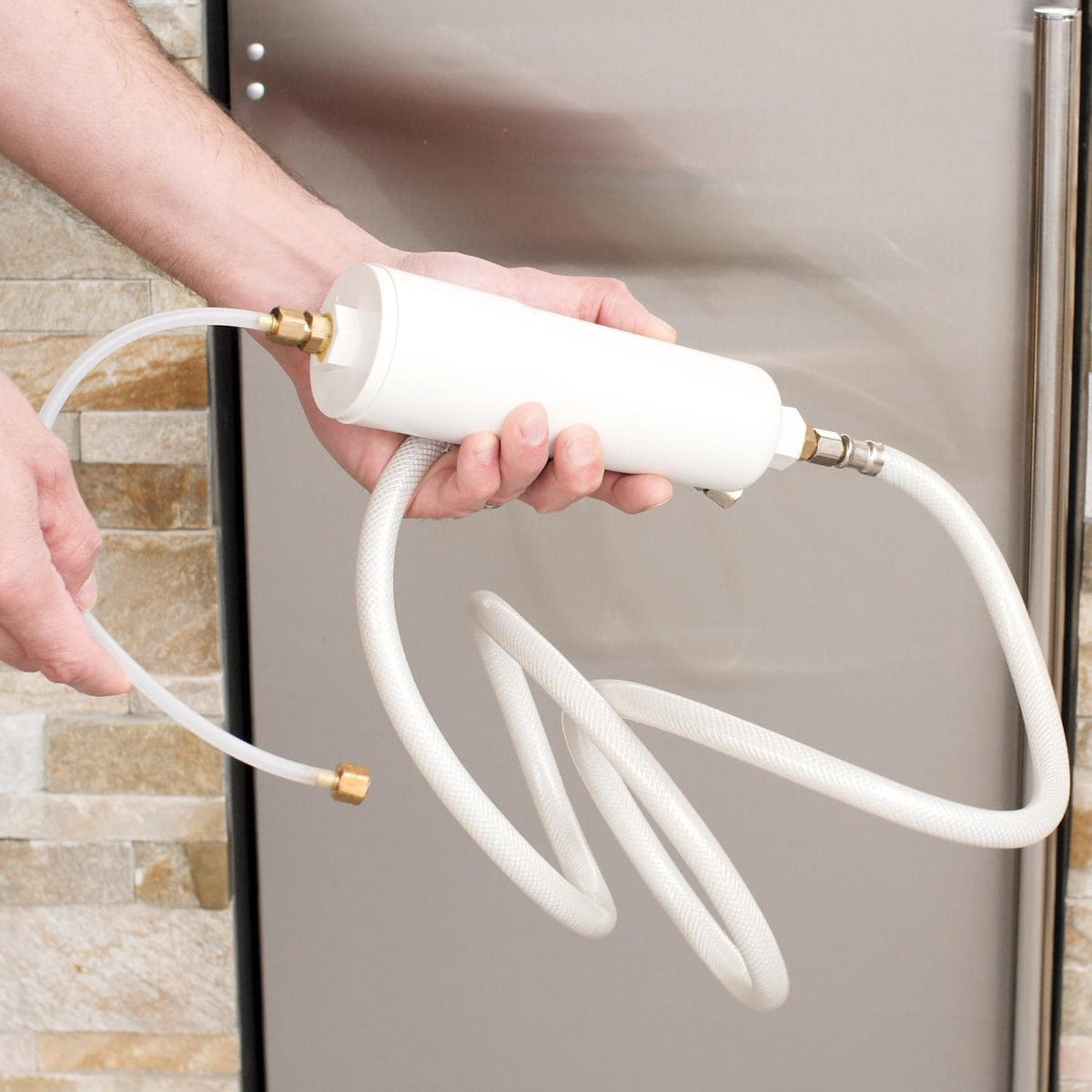 Gravity drain hose connection with white tubing and brass fittings