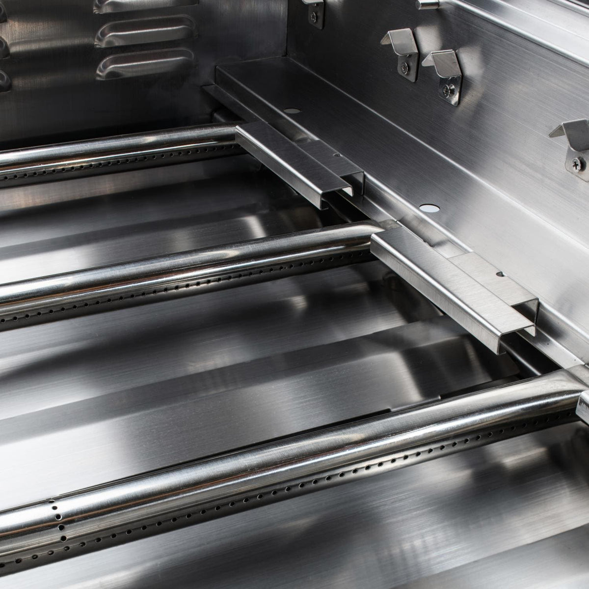 Stainless steel grill interior with metal bars and open hood