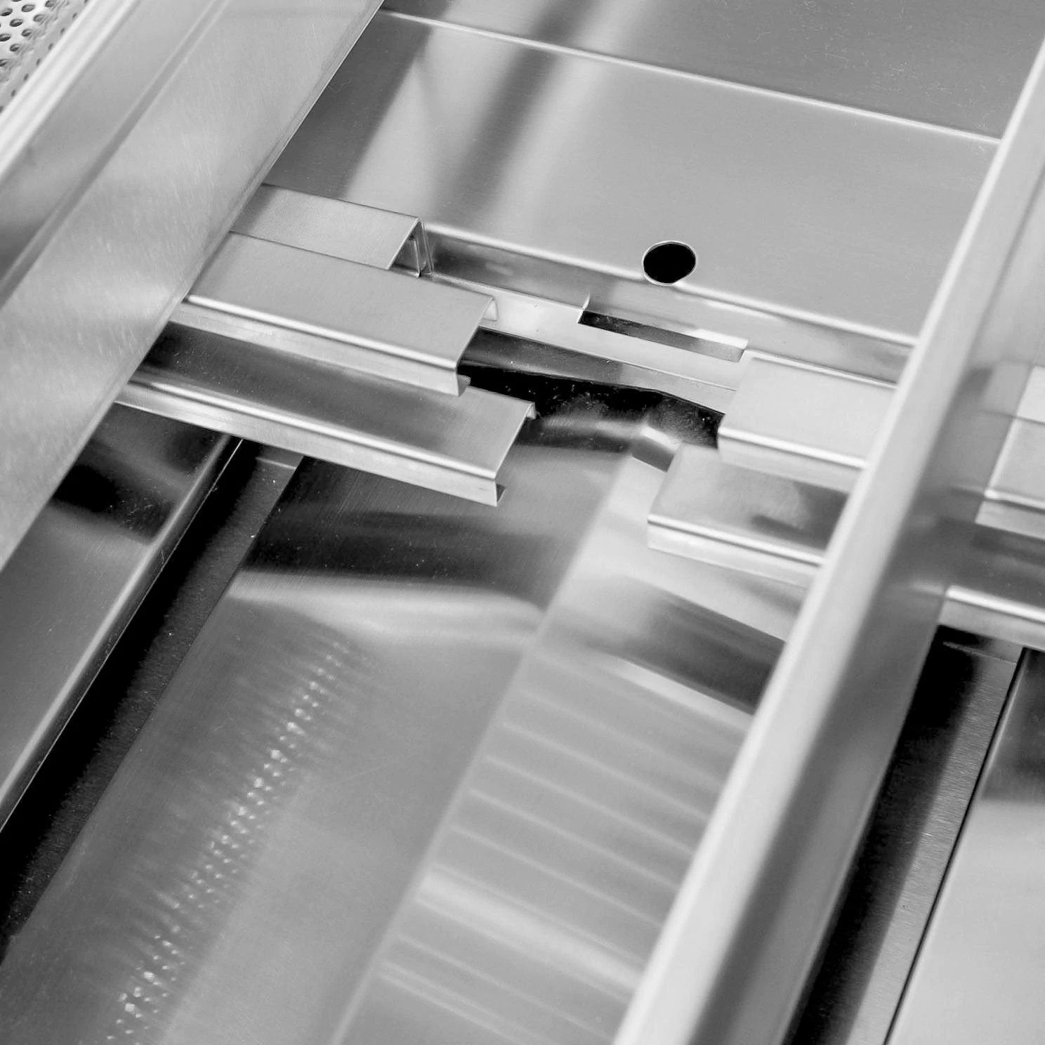 Stainless steel built-in gas grill interior with burner assemblies and metal grates