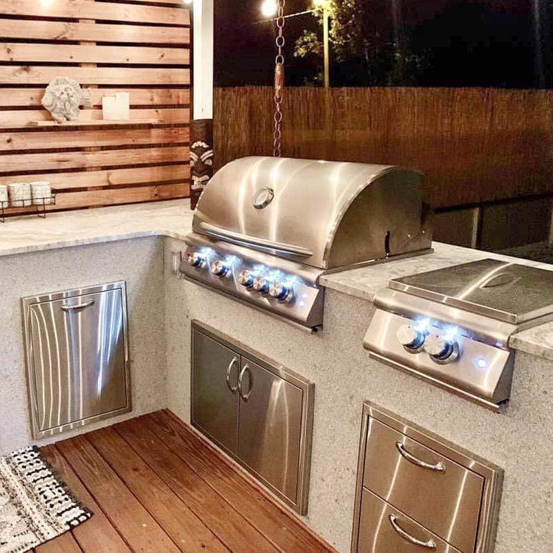 Stainless grill with glowing LED lights over burners, control panel and doors