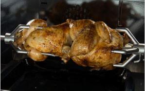 Stainless range oven with rotisserie-style roasting chicken on spit