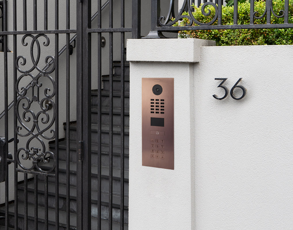 Bronze IP video door intercom mounted on gate post with keypad and camera lens; 36