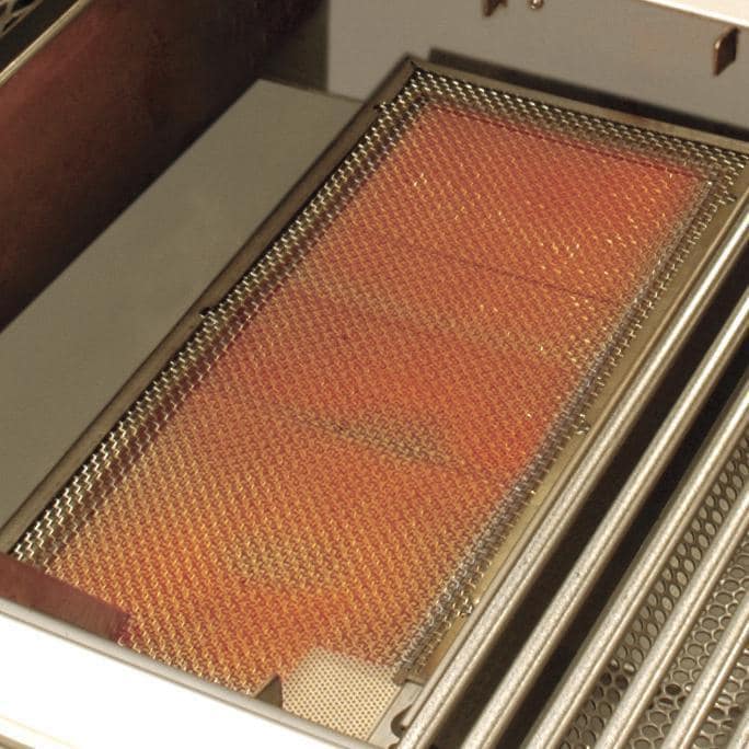 Glowing orange infrared burner heating mesh inside stainless grill