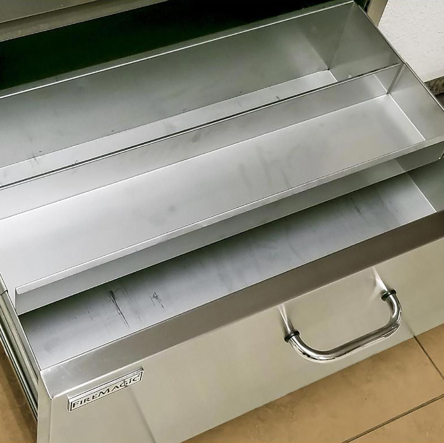 Open flush masonry drawer with metal interior rails and Fire Magic logo