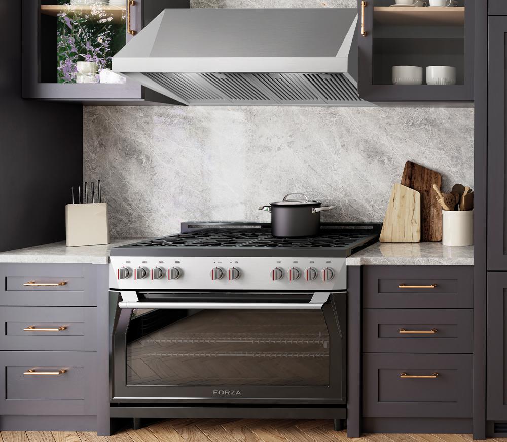 Stainless steel range hood with vent slats above a countertop cooking range