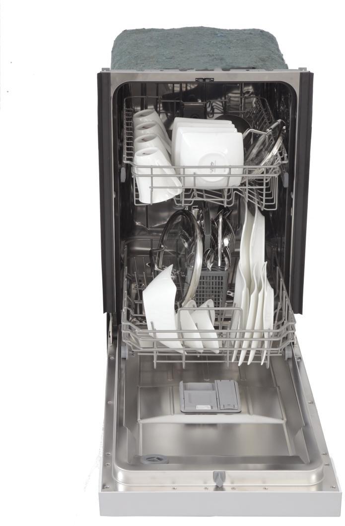 Dishwasher door open with racks of white plates, cups, and utensils