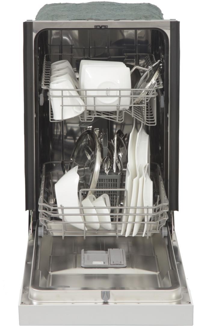 Open dishwasher interior with loaded racks and silverware in stainless tub