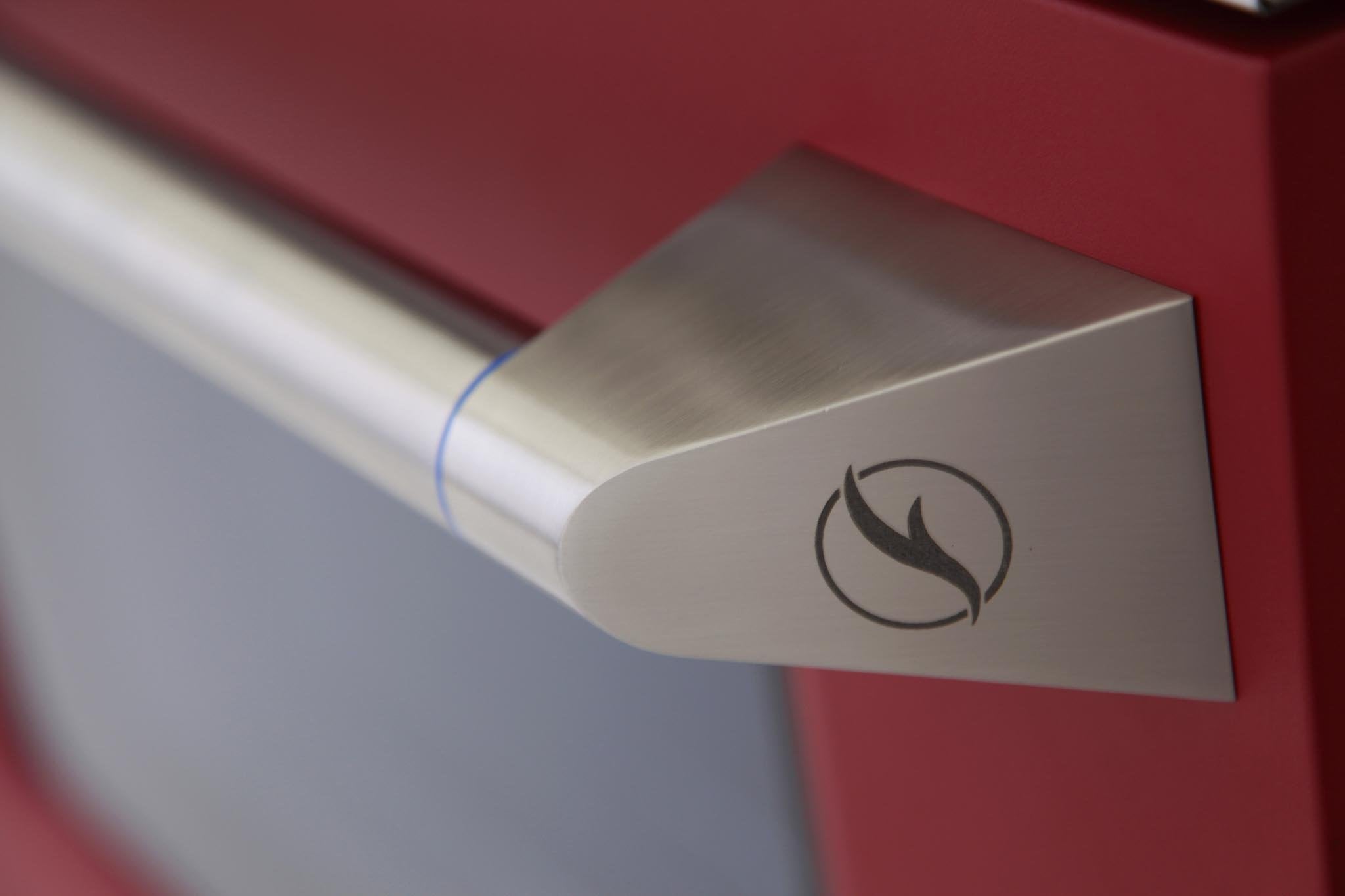 Stainless oven handle with flame icon on red gas range