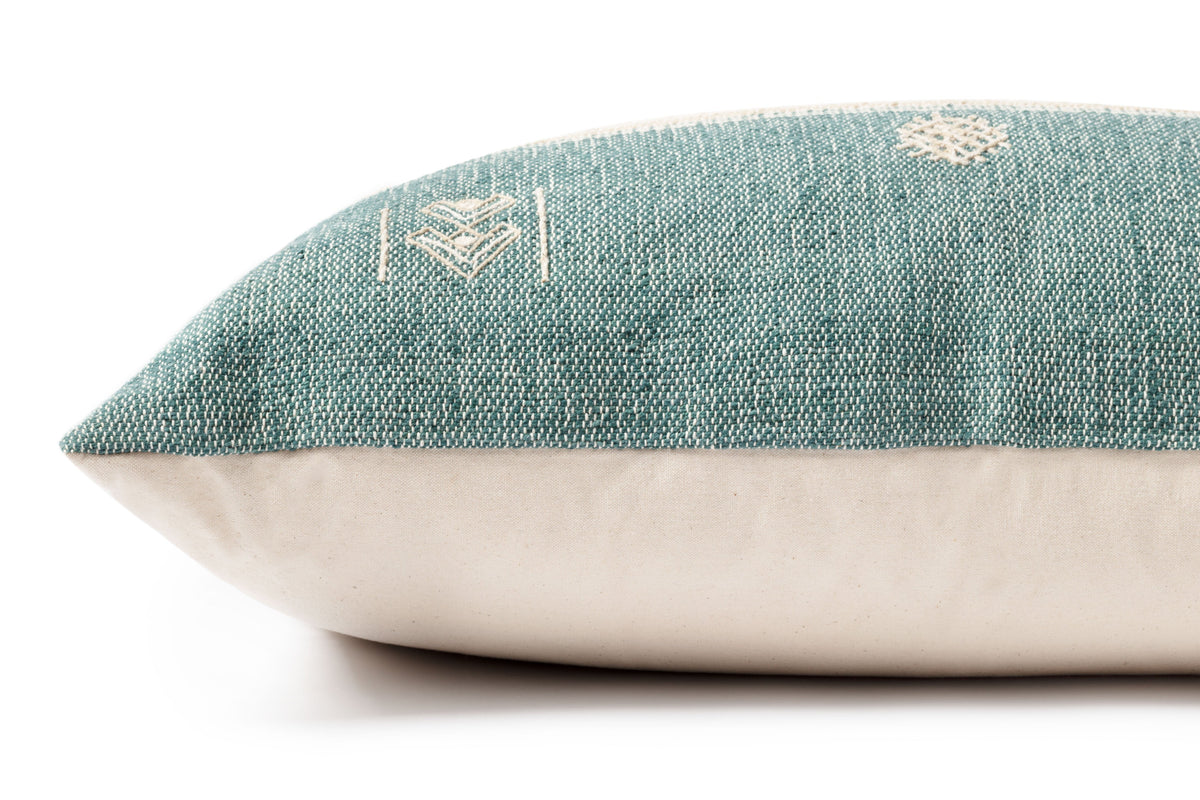 Teal decorative pillow with geometric embroidery, side seam, and cream backing