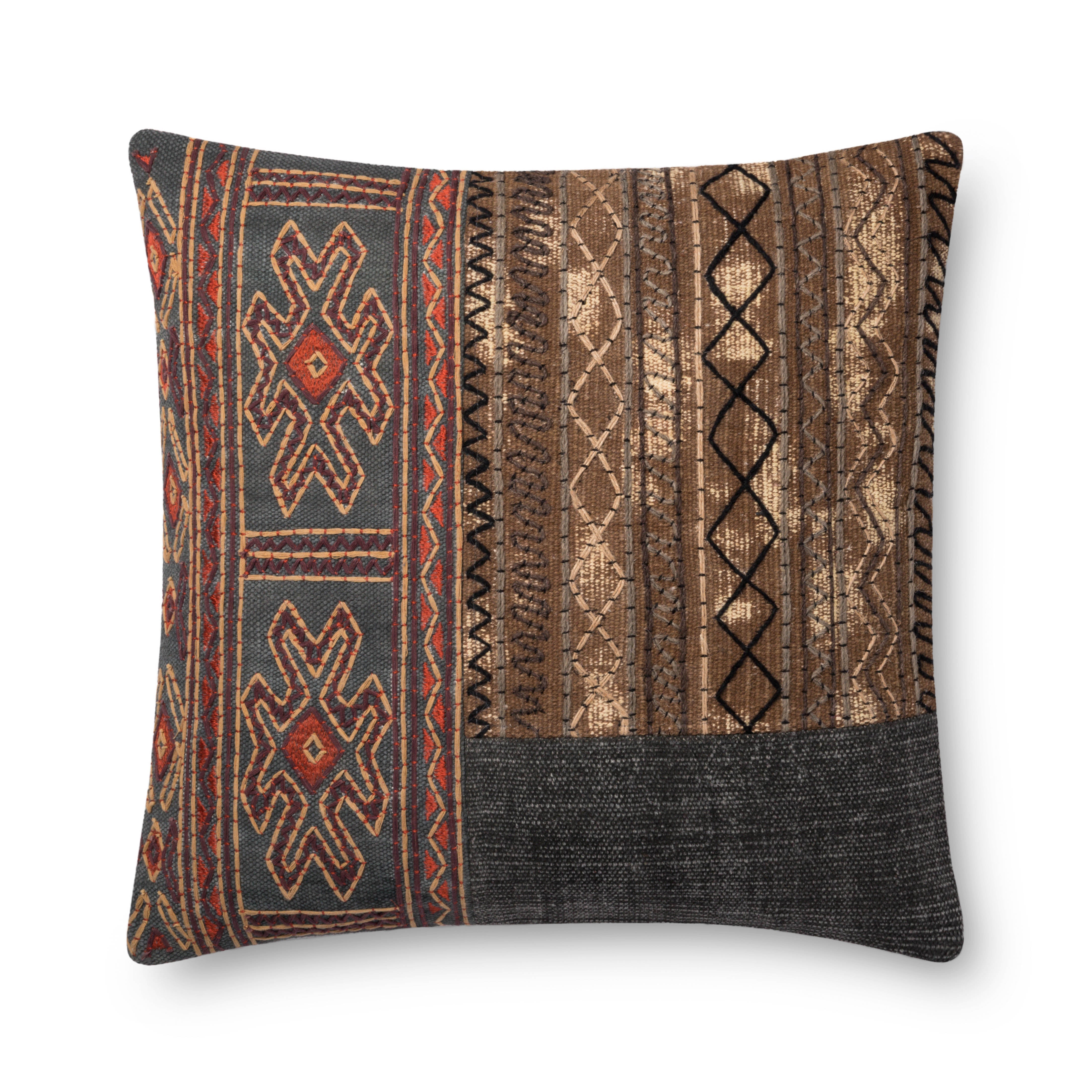 Loloi pillow with geometric patchwork in grey, brown, black, and rust orange.