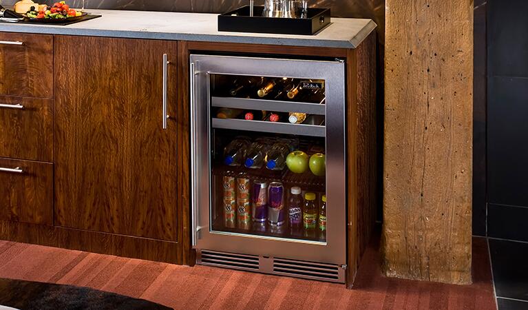 Built-in stainless beverage center with open glass door, stocked with bottles