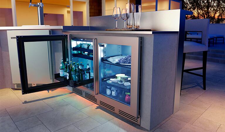 Stainless steel counter-depth refrigerator, glass door open showing interior shelves.
