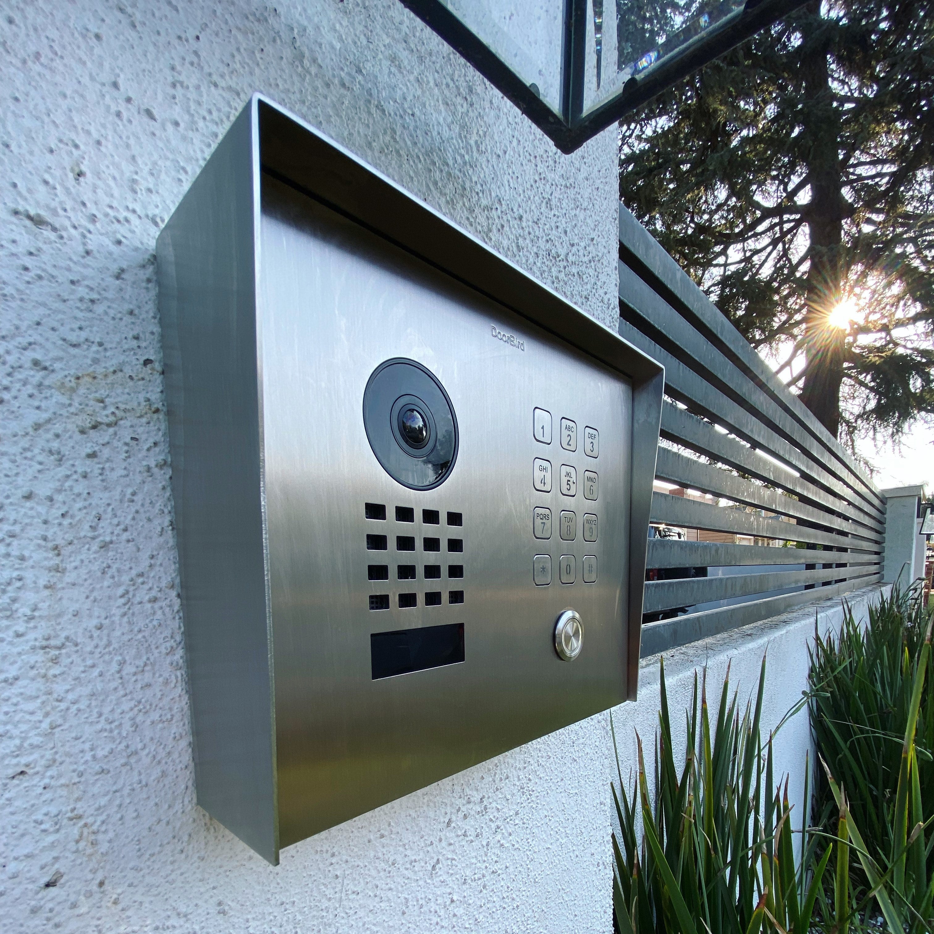Stainless steel wall-mounted video door station with camera lens, keypad, and call button