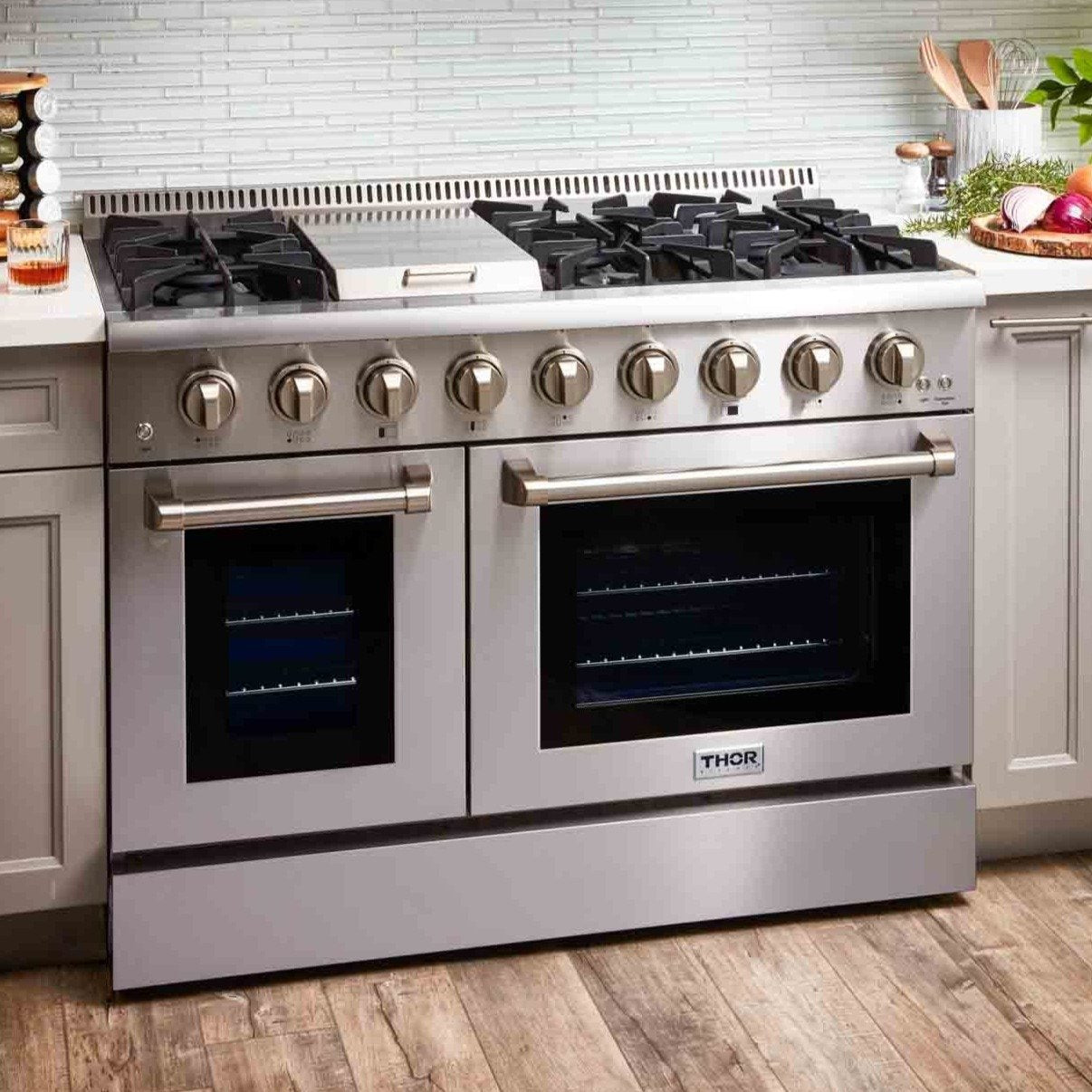 Stainless steel dual fuel range with gas burners and dual ovens, front close-up.