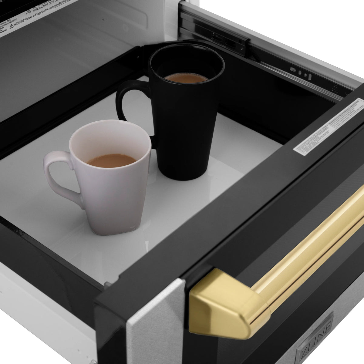 Microwave drawer interior with two mugs on tray and gold-accent handle