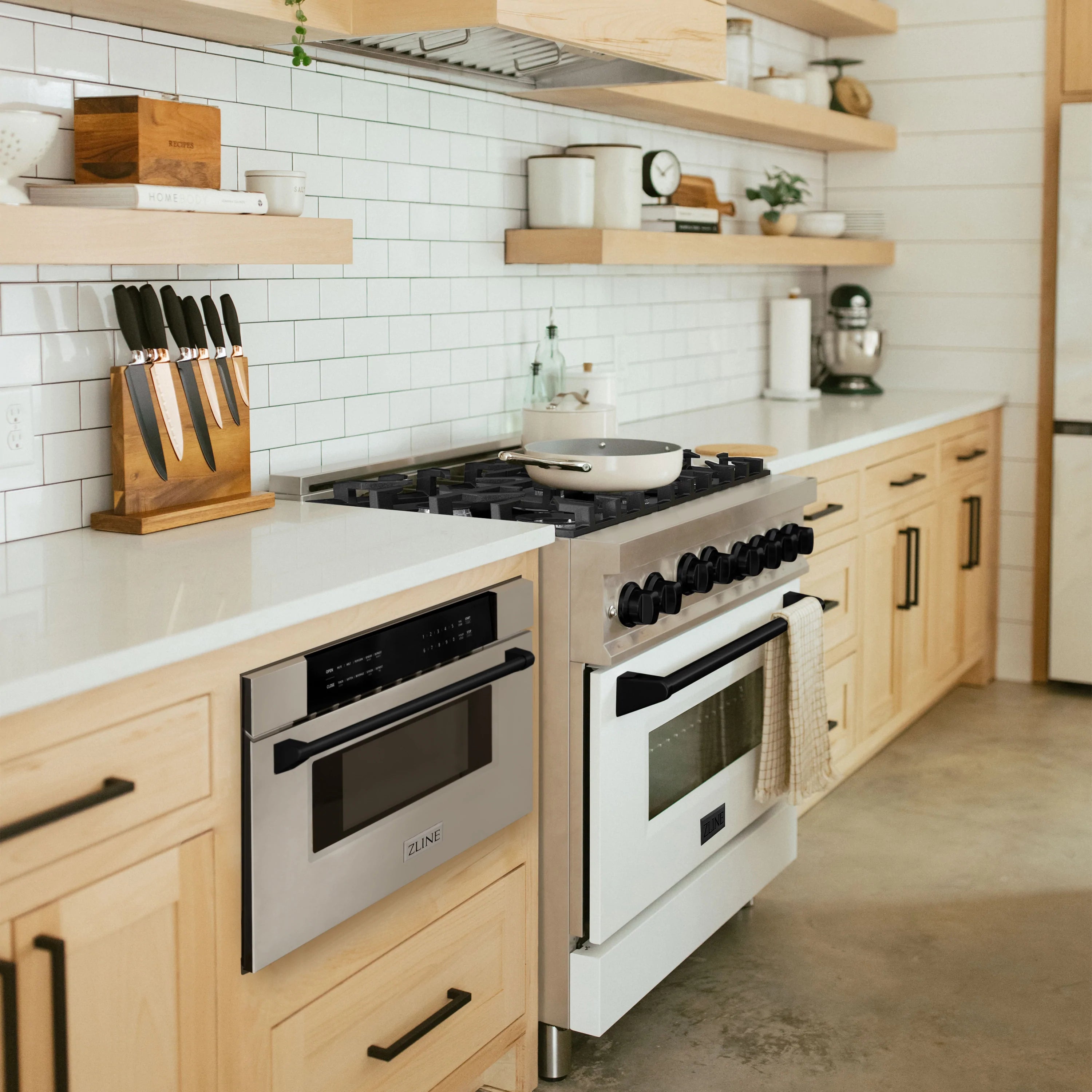 Stainless steel microwave drawer with matte black trim installed in kitchen cabinetry