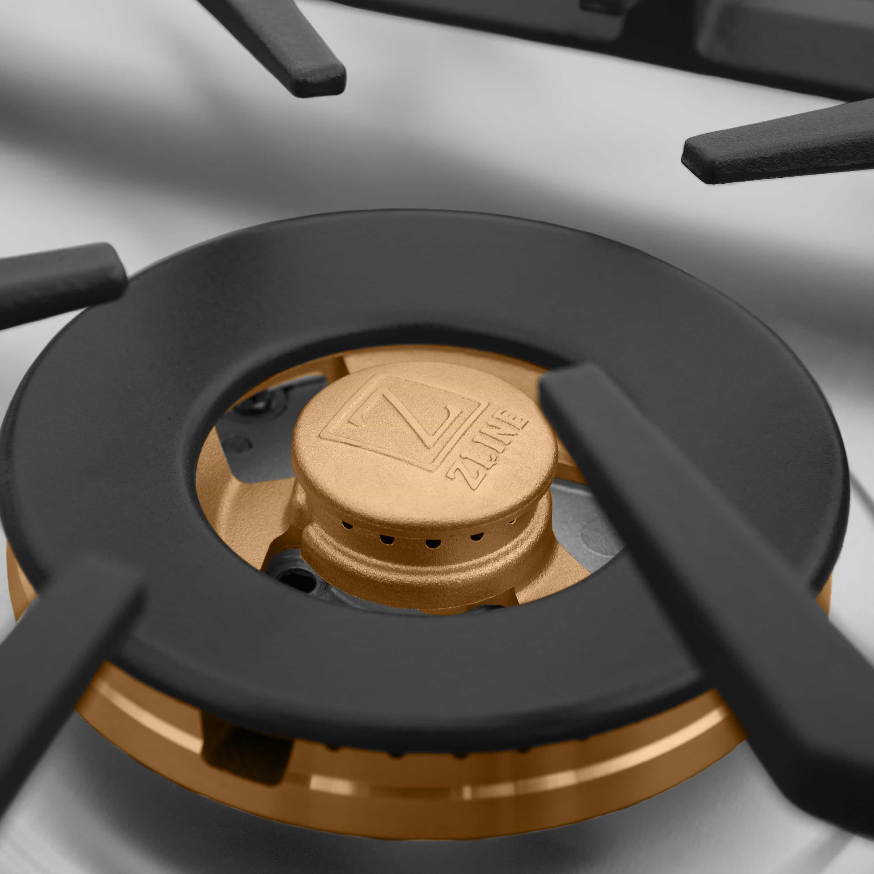Close-up of a gas cooktop burner base with brass ring and black burner cap