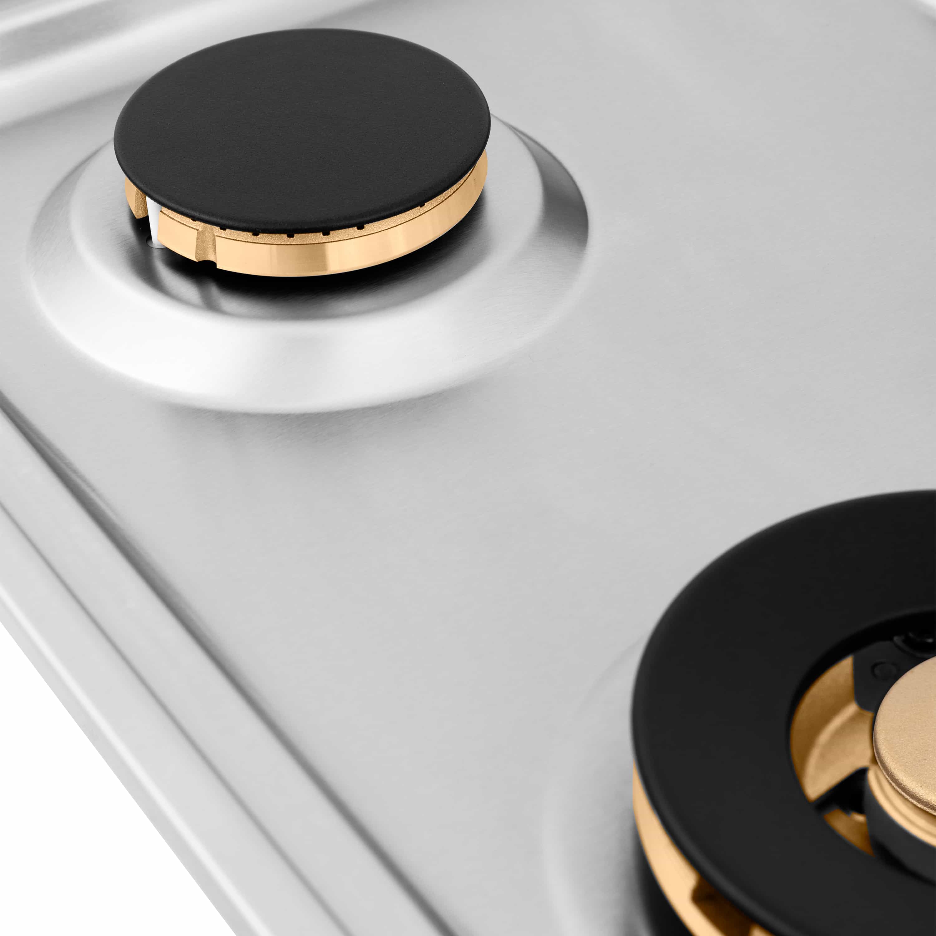 Gas cooktop with two burners, black caps, and brass ring details on white top