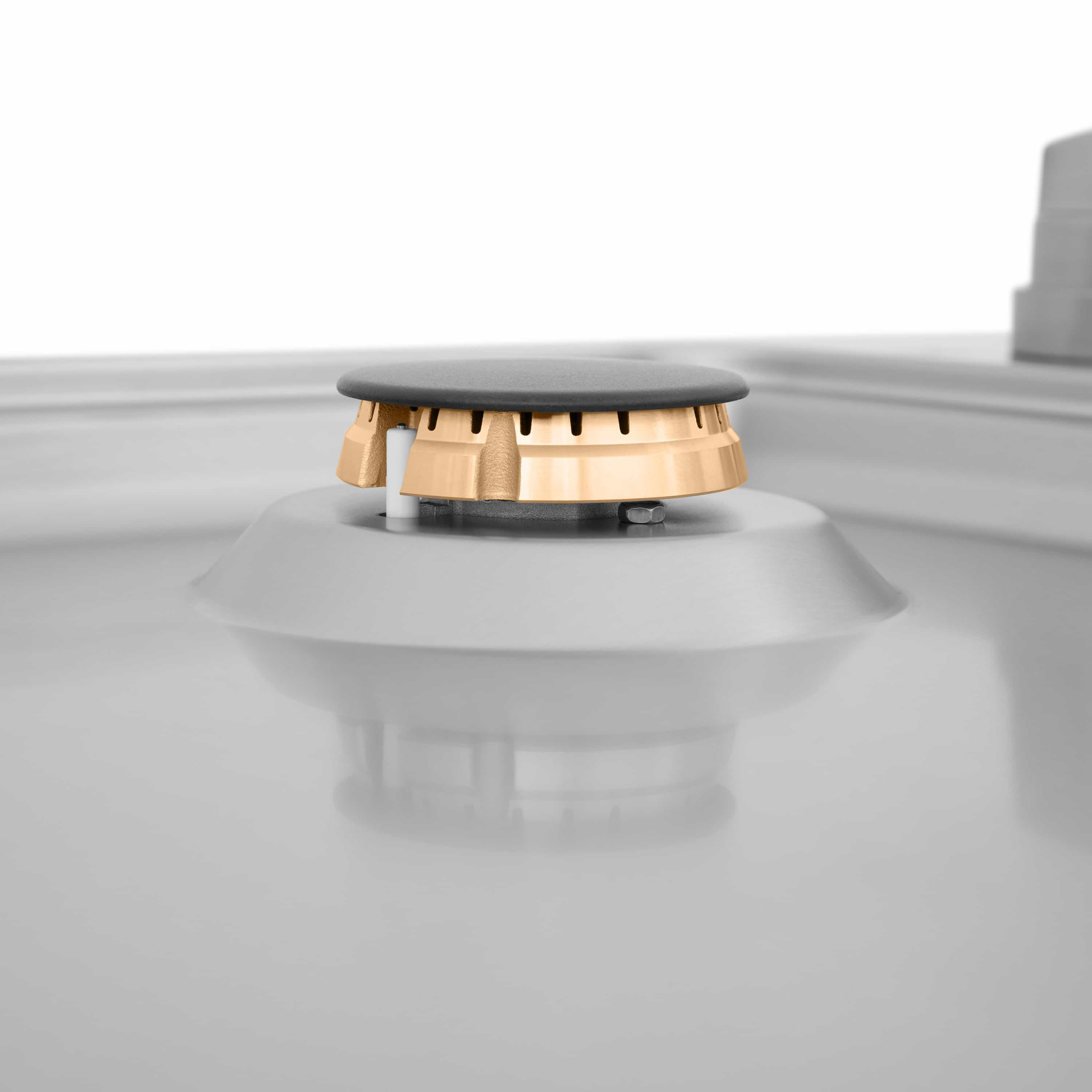 Isolated gas cooktop burner cap with brass base ring, side close-up