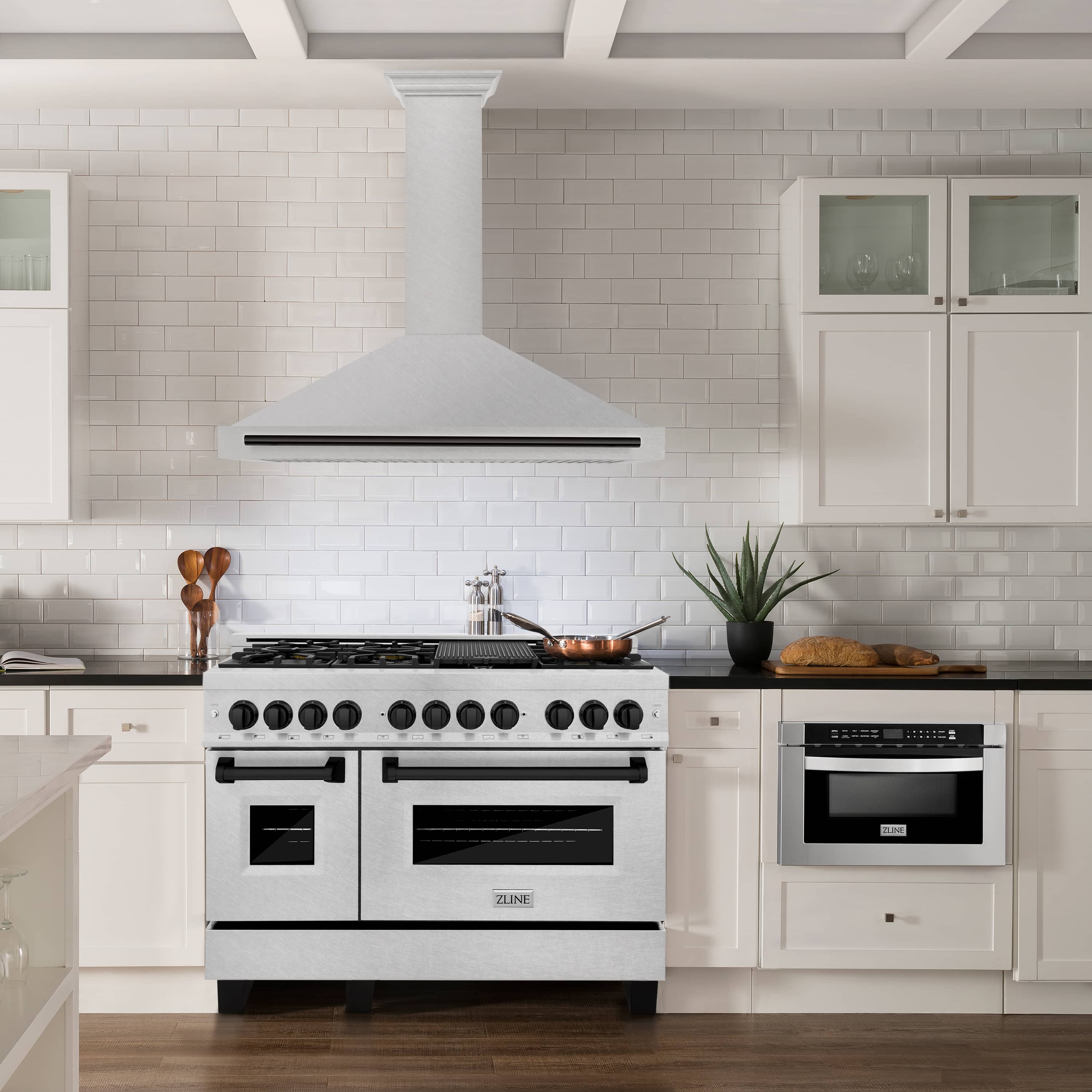 Wall-mounted range hood with satin stainless-steel chimney and matte black edge handle