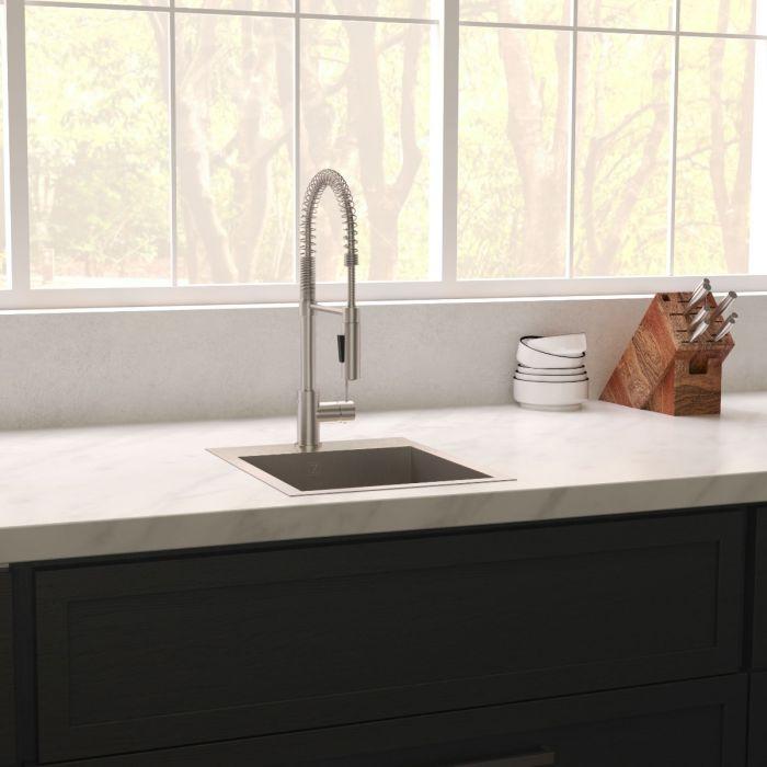 Stainless steel single-bowl sink with faucet on countertop near window