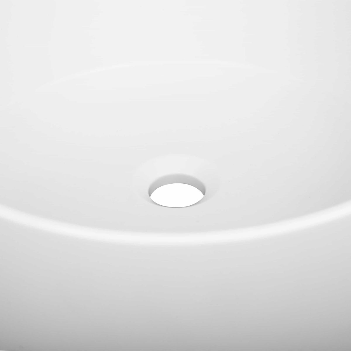 Matte white round vessel sink, close-up of top surface and centered drain opening