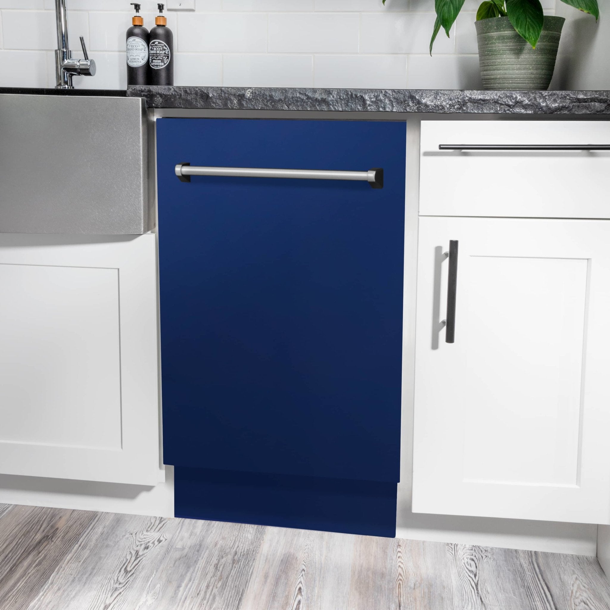 Installed blue dishwasher door with stainless handle.