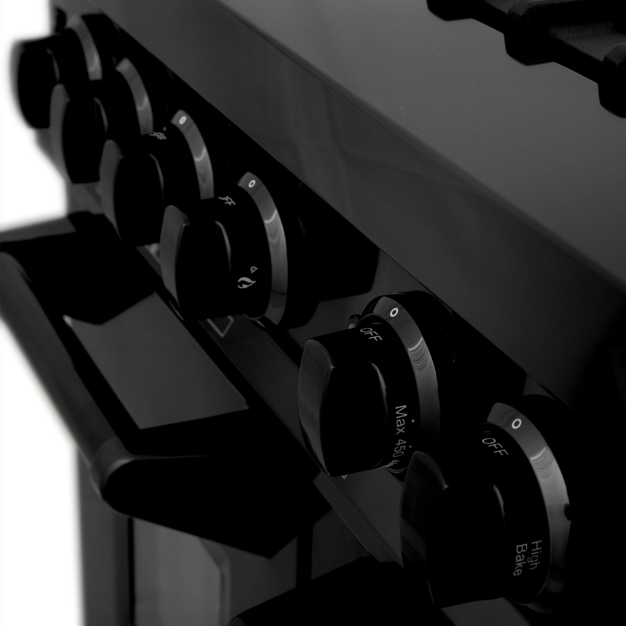 Black range hood control knobs with marked settings and off symbol