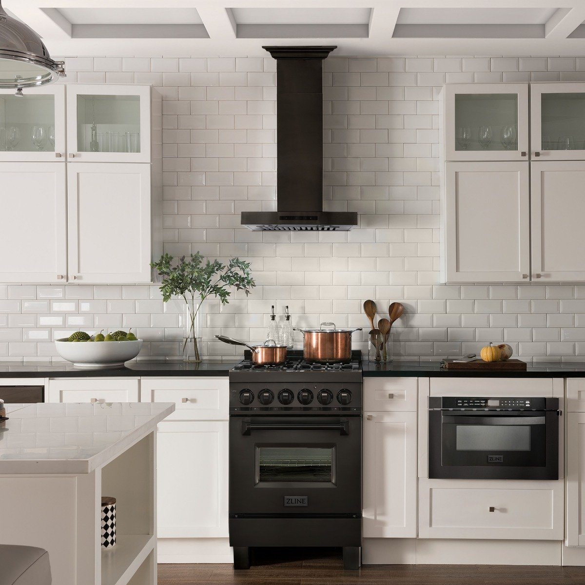 Black wall-mount range hood installed over cooktop, with control light bar