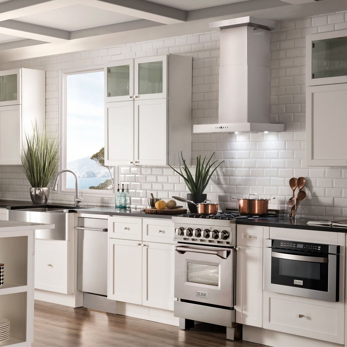 Stainless steel wall mount range hood installed above cooktop with decorative trim
