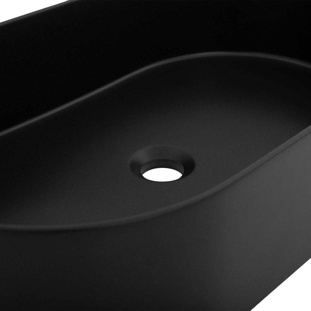 Matte black vessel sink close-up showing round drain opening